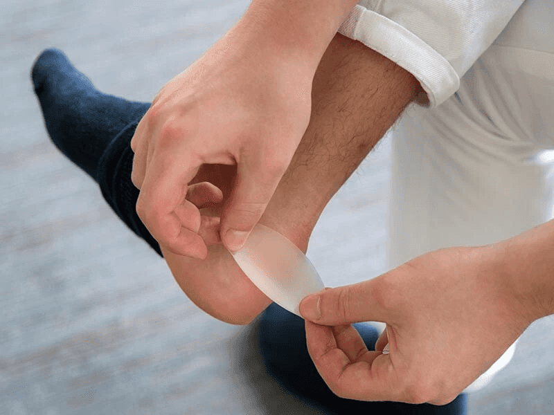 Somebody putting a blister plaster on their heel